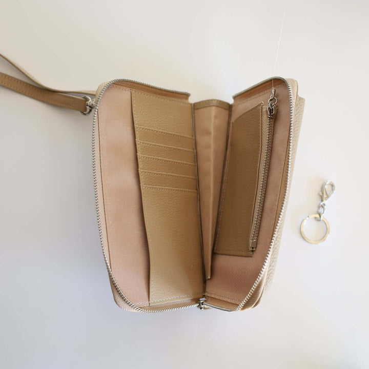 Inside the beige pebbled leather phone crossbody wallet. We can see the 5 card compartments, together with the bill compartment the coin pocket and the detachable keyring. The lining and the leather inside are beige also.