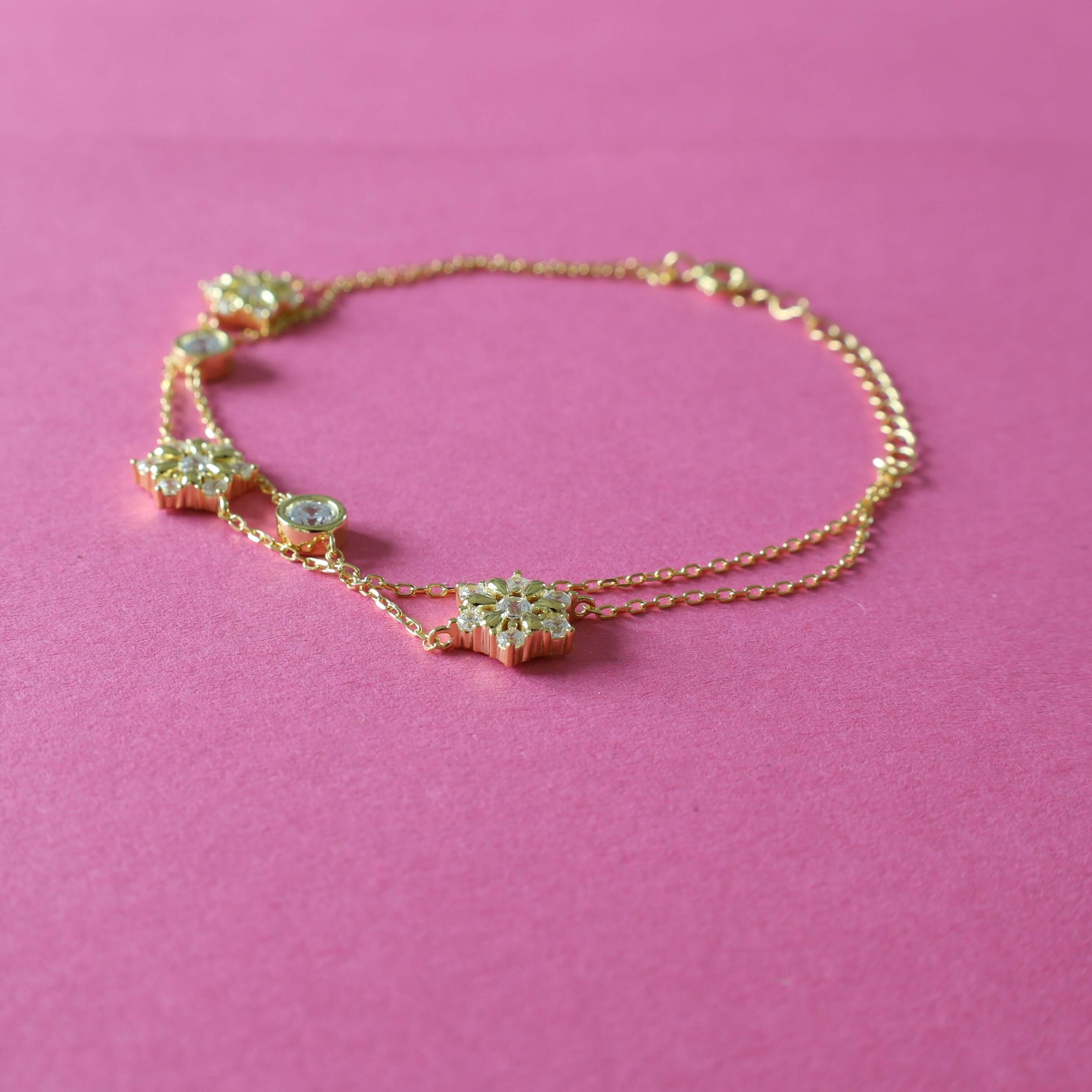 Golden bracelet with snowflakes and round zirconia.