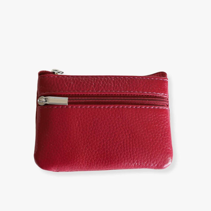 Small red leather double zipper wallet with an embedded gray metal keychain, the wallet is shown when closed.