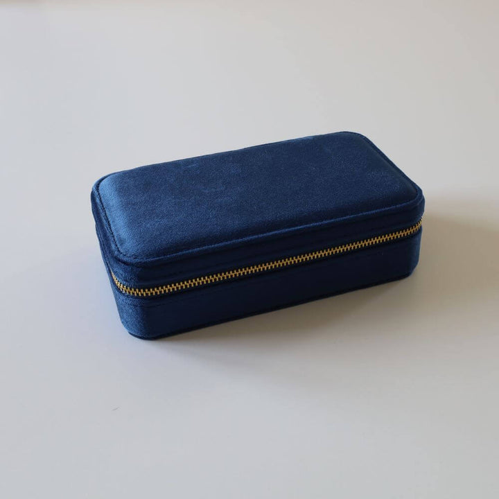 Rectangular blue velvet jewelry box with a golden zipper.