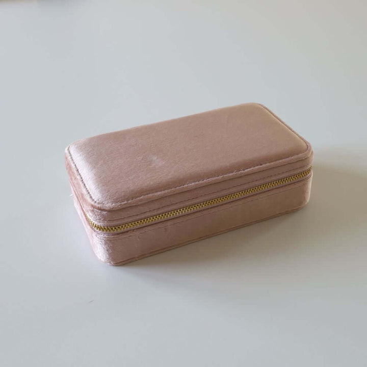 Rectangular pink velvet jewelry box with a golden zipper.