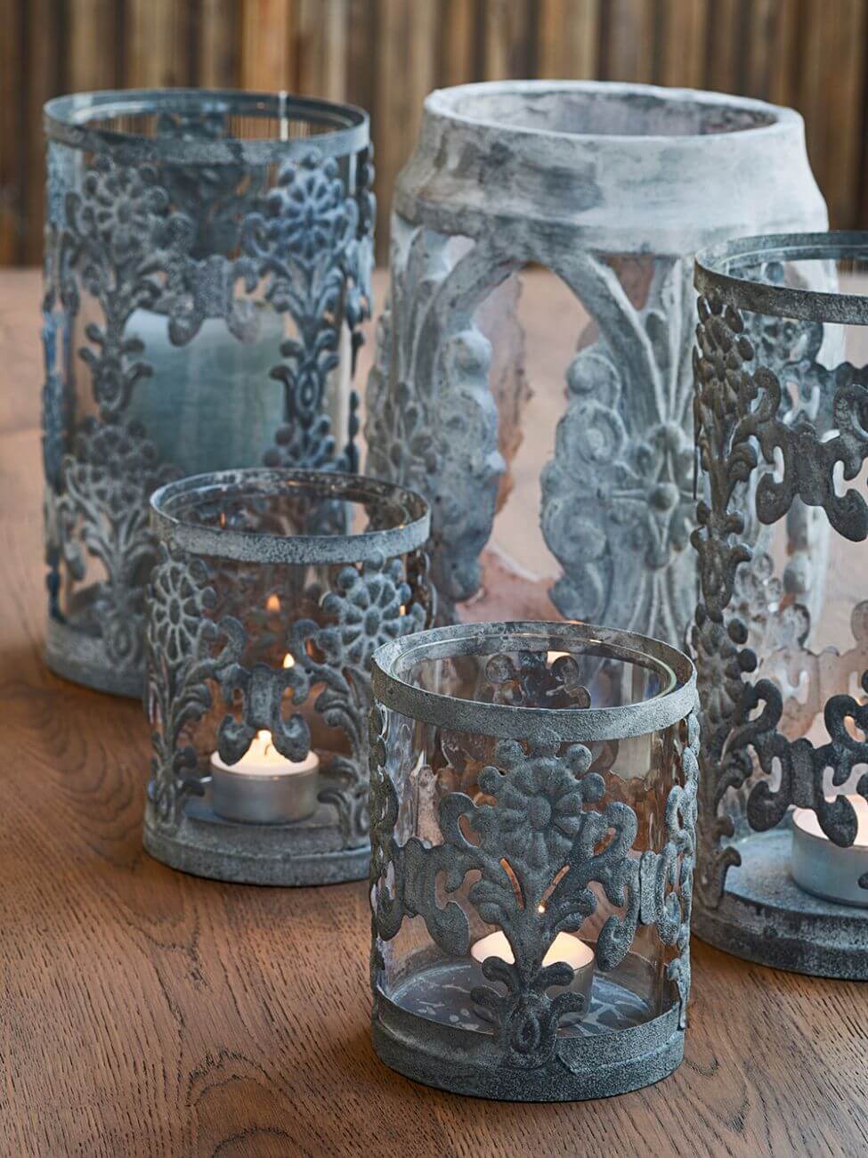Gray metal candelholders, two small and three largers.