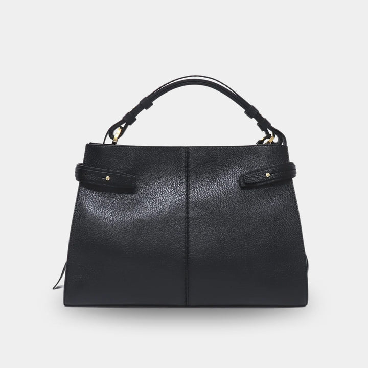 Black pebbled leather top handle bag with a leather tab on each side adorned with a gold-tone stud. Front view.