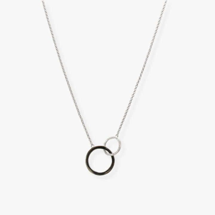 Two interlocking circles of different sizes suspended from a silver chain.