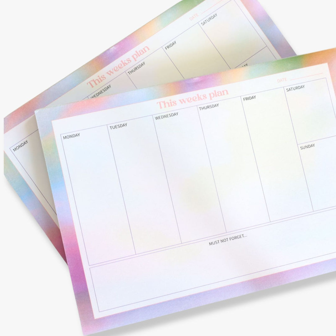 Weekly planner with space for a weekly agenda and notes. The pad features a gradient border with shades of blue and purple. Close up view.