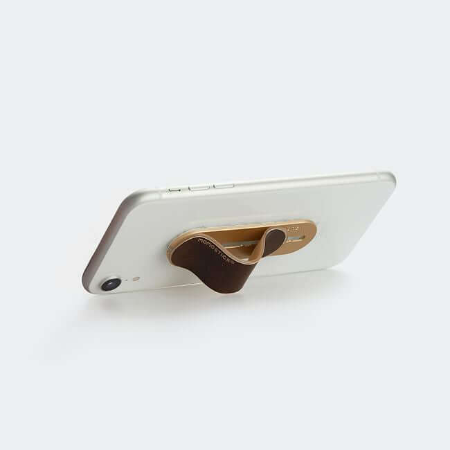 Brown phone grip holder used a stand for a phone.