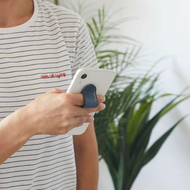 Man holding a phone with a blue phone grip holder.