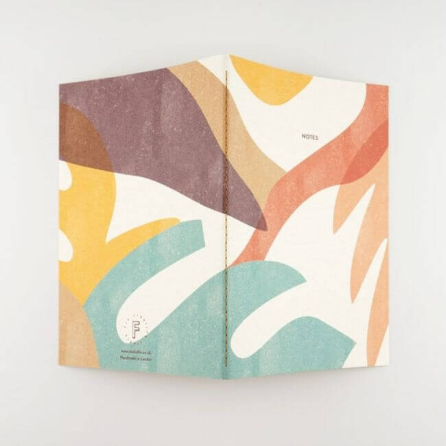 Notebook with a colorful botanical print on the cover: back view.