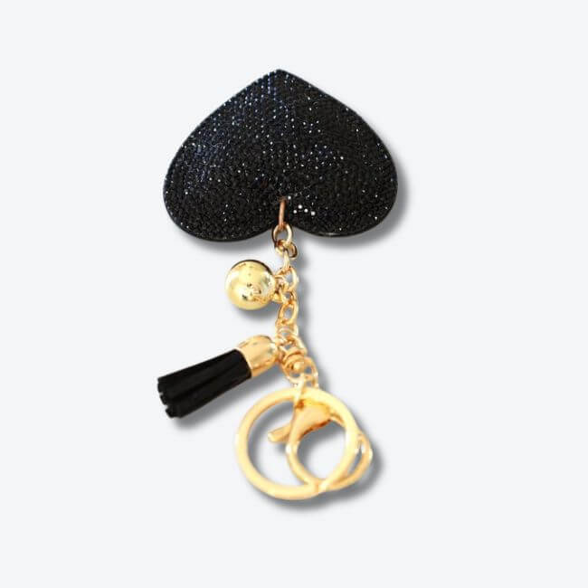 Keychain adorned with a black rhinestone heart pendant and a faux suede tassel