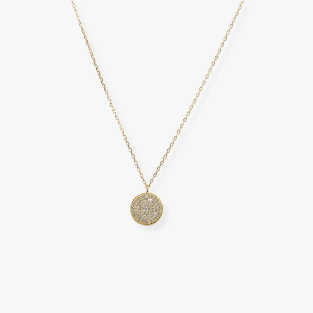 Golden necklcae with a disc-shaped pendant set with zirconia.