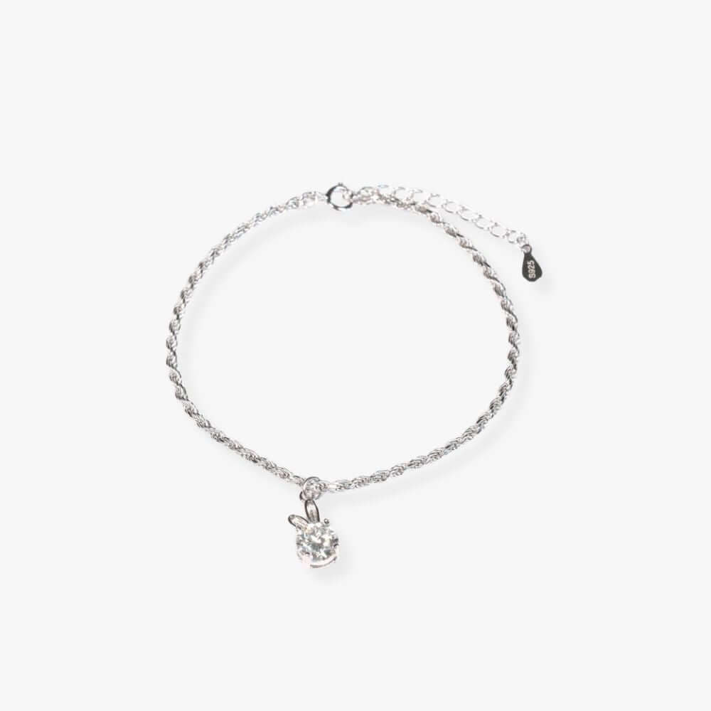 Silver bracelet featuring a flower-shaped pendant set with a synthetic gem that shines.