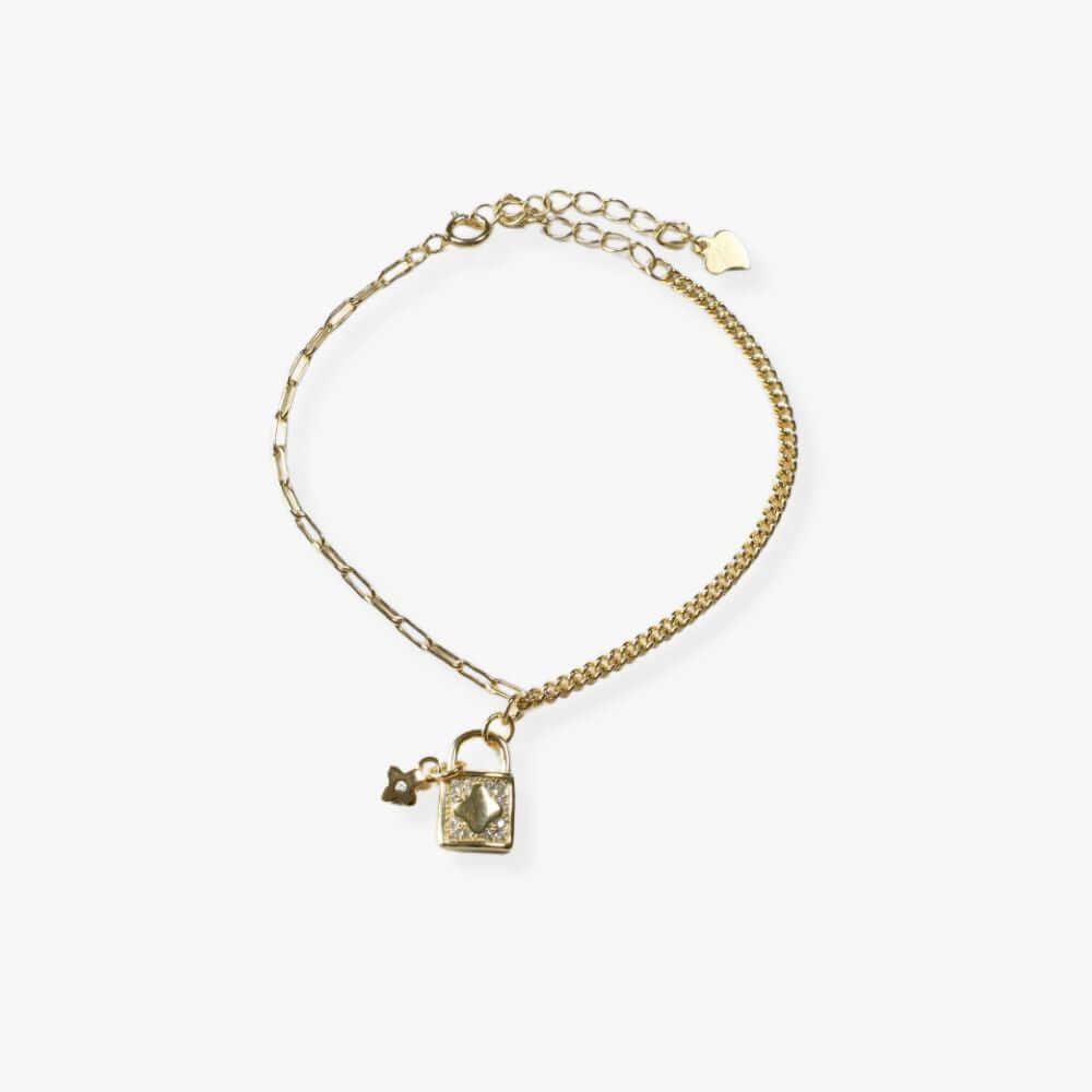 Gold plated bracelet with a padlock charm and a four-leaf clover charms suspended together to the  bracelet.