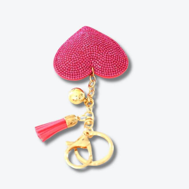 Keychain adorned with a pink rhinestone heart pendant and a faux suede tassel