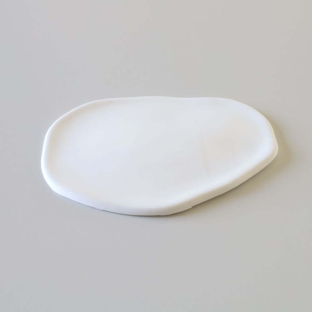 Flat and smooth ceramic ring dish that has the shape of a cloud.