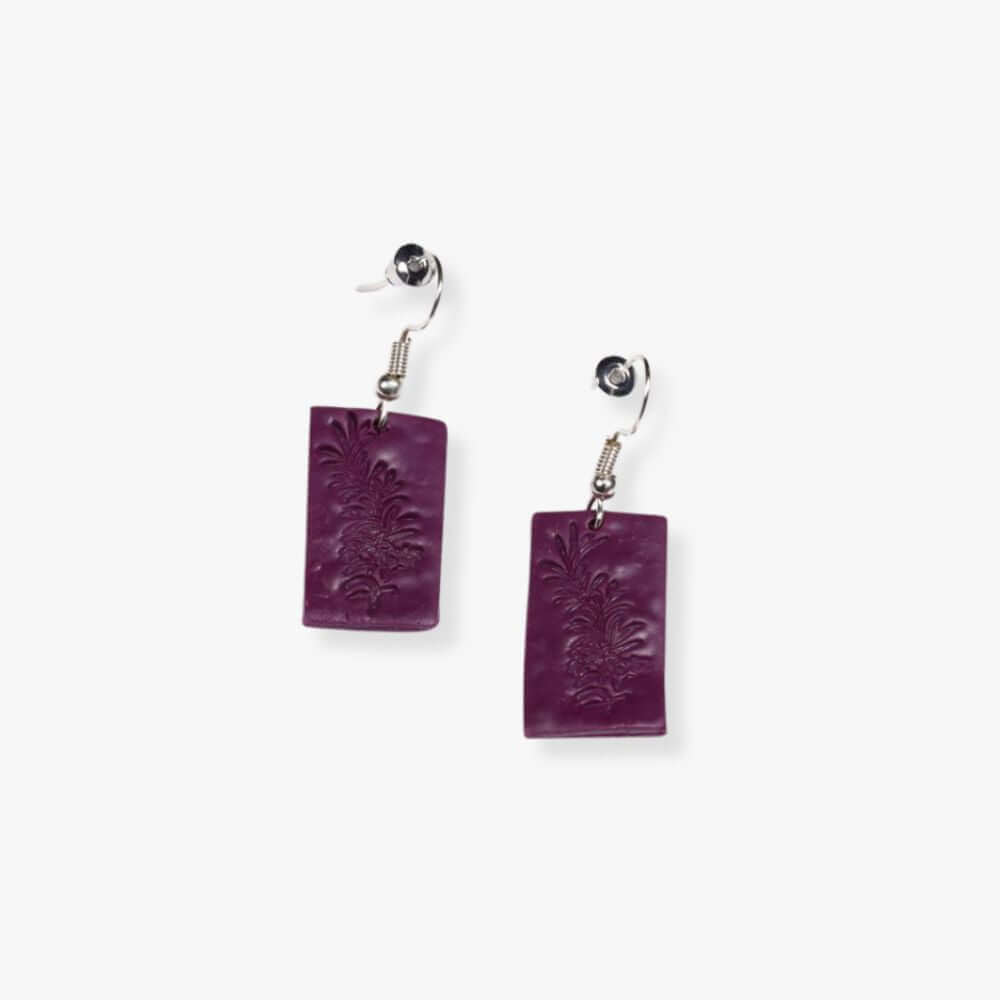 Rectangular violet pendant earring hanging from a metal hook-