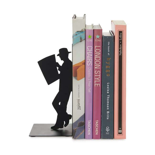 Black metal bookend with a cut out of a man reading a newspaper: view with modern books.