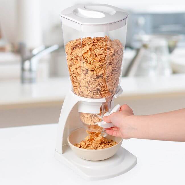 White and clear plastic cereal and dry food dispenser on a kitchen counertop.