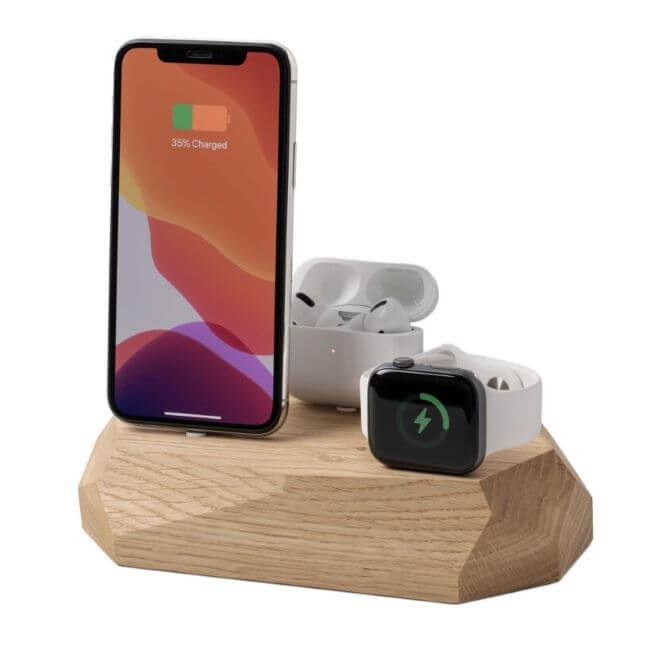 Oak charging station with an iPhone on the left, a white Apple® Watch  on the right and Airpods in a white case in the middle.