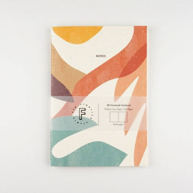 Notebook with a colorful botanical print on the cover: front view.