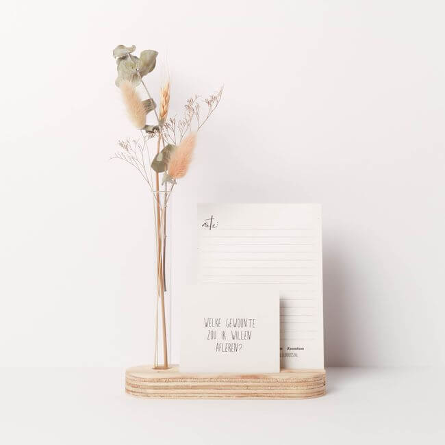 Wooden card display stand with two cards and a bud vase holding dried flowers.
