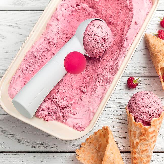 White ice cream scoop with a pink ball trigger in a pink ice cream box.