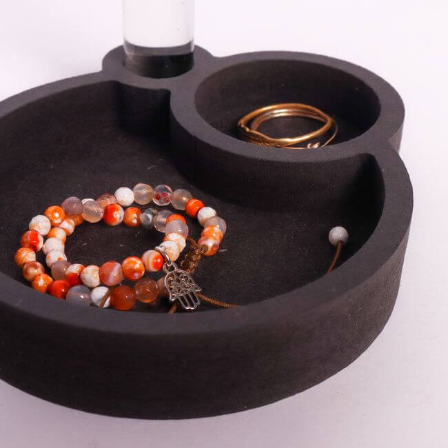 Black jewelry tray with two round compartments: close-up view.