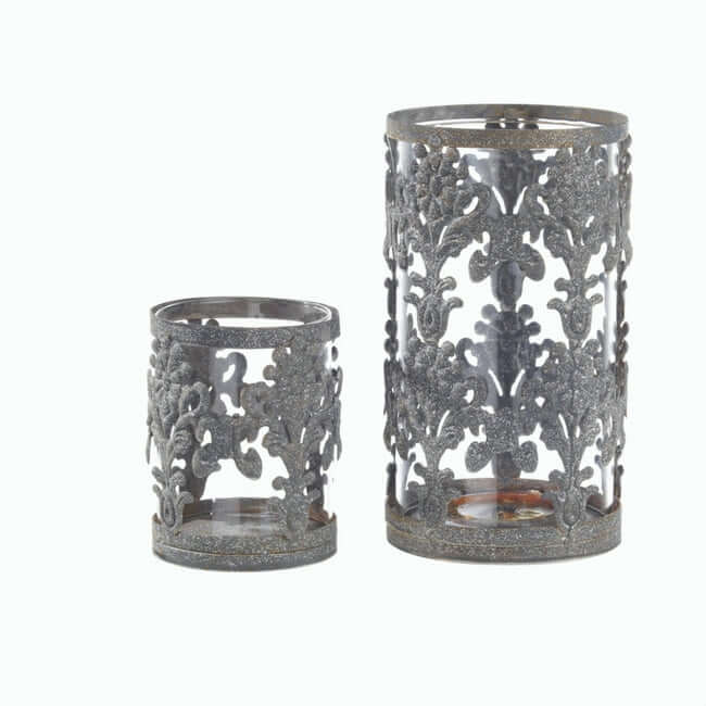 Set of two metal hurricane candle holders with glass inserts.