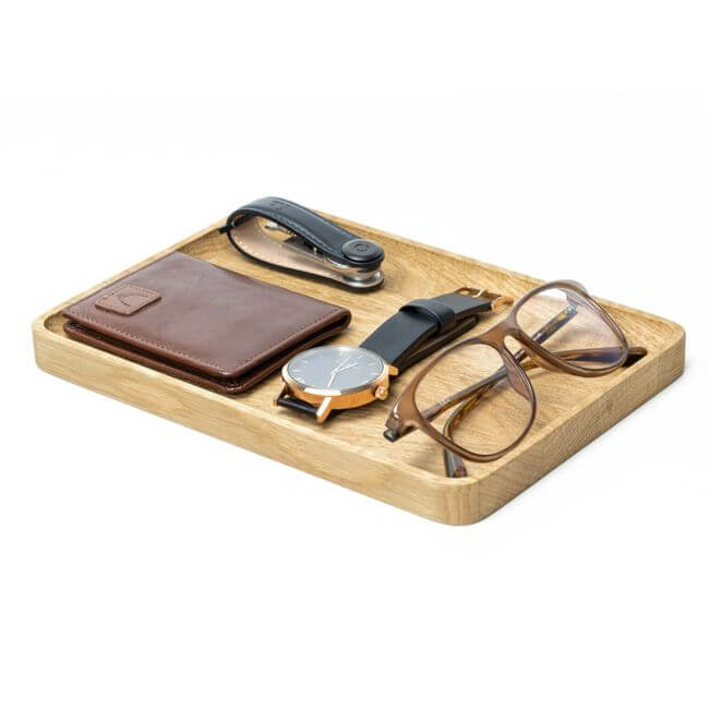Oak valet tray holding a wallet, a watch, eyeglasses and a keychain.